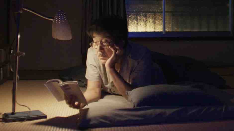 هیرایاما در حال مطالعه کتاب در زیر نور چراغ مطالعه